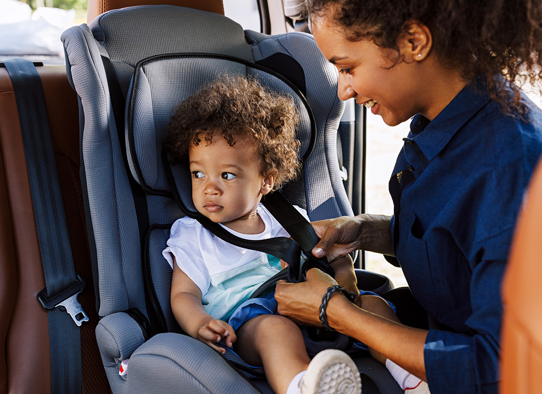 About Our Agency - Mother Strapping in Baby in Carseat